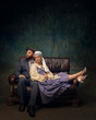 © master1305 - Vintage couple relaxing on couch. Van Gogh and Girl with white pearl relaxing on modern leather couch. Fusion of old-world elegance and modern leisure. Concept of eras comparison, creative vision, ad