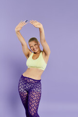 A young bald woman showcases her vibrant outfit while expressing pure joy in playful dance.