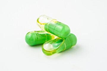 Transparent capsules with a mixture of green powder and oil, Food supplements, vitamins