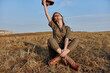 © SHOTPRIME STUDIO - Woman enjoying freedom outdoors with hands in air holding hat in travel fashion beauty concept