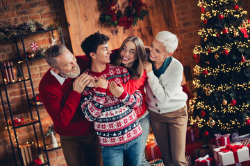 Wall Mural - Photo of family meeting grandfather grandmother hug grandson granddaughter in christmas decorated room house indoors