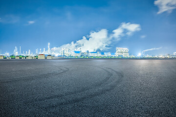 Poster - Empty asphalt road and petrochemical plant industrial buildings at night