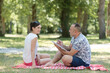 © auremar - man making a sketch of his partner at the park