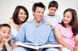 © STEEX/peopleimages.com - Happy family, children and parents reading book, learning story or siblings bonding together in home. Kids, mother and father storytelling in bedroom for morning education, fantasy fairytale or relax