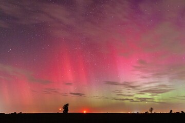 Mesmerizing view of the northern lights with vibrant red and green hues illuminating the night sky