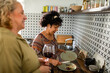 © Marko Geber - Senior lesbian couple doing dishes after meal in kitchen