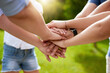 © peopleimages.com - Hand stack, family and parents with kids outdoor for team building, support and vacation celebration. People, palm and circle with game agreement, partnership and summer community for nature bonding