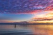 © Wirestock - Sunset over calm waters with dramatic clouds reflecting hues of pink, purple, gold in Shoreline Park