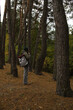 © Наталья Николаева - tourism. a tourist with a gray-burgundy backpack, mugs, a lantern with a compass travels through the wild forest