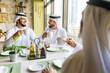 © oneinchpunch - Arabian businessmen at restaurant cafè