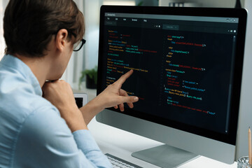 IT developer selecting by point on coding online software development information on pc comparing with laptop screen of new code program's update version firmware overall system project. Pecuniary.