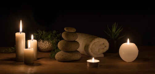 Decoration in.low light. Set with stones, candles, plants and towel. D set with stones, candles, plants and towel. Decor for relaxation, massage, meditation and aroma therapy environments