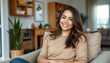© Pavel Lysenko - Young woman smiling in cozy living room, showcasing warm decor and relaxed atmosphere during daylight hours