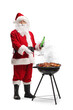 © Ljupco Smokovski - Full length shot of Santa claus grilling meat on bbq and drinking beer