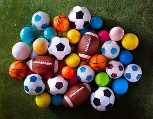 A group of different colored soccer balls on the field