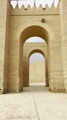 Wall Mural - Walking through archs in Babylon great walls restored by Saddam Houssein. Babylon, Iraq. Vertical