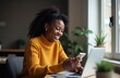 © Svetlana Lavereva - Beautiful smiling black young woman, using phone for networking or social media at office, reading text message, tying, chatting on internet, making video call.