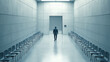 © Nano Photos - A person walks down a long, stark hallway lined with empty chairs, heading towards an open door. The atmosphere is minimal and mysterious.