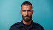 © RISHAD - Confident bearded police officer against blue background