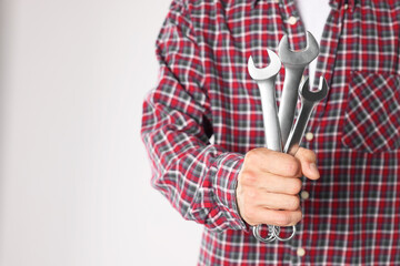 Wall Mural - Auto mechanic with wrenches on light grey background, closeup. Space for text