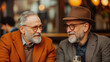 © Nano Photos - Two elderly men, dressed warmly and smiling, enjoy a conversation in what appears to be a cozy caf? setting with soft lighting in the background.