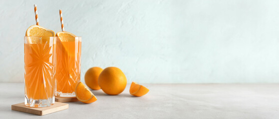 Wall Mural - Glasses of fresh orange juice and fruits on white table