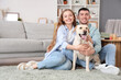 © Pixel-Shot - Happy young couple with Labrador dog sitting at home