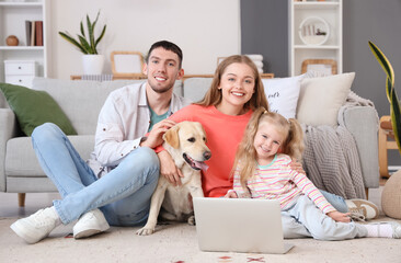 Poster - Happy family with Labrador dog and laptop at home