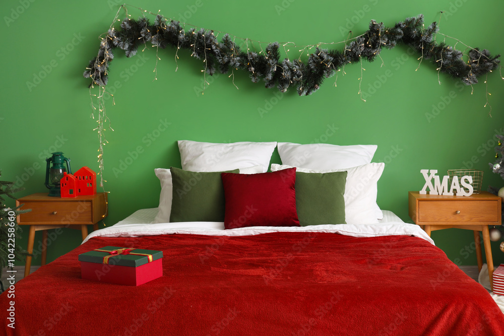 Interior of bedroom with bed, Christmas branches and tables