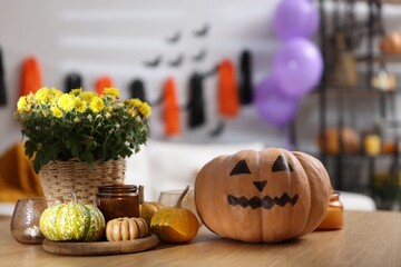 Poster - Halloween celebration. Pumpkin with creepy face, flowers and candles on wooden table