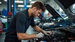 © SEYYAH - Mechanic working on a car engine in a busy automotive workshop during daytime repair tasks