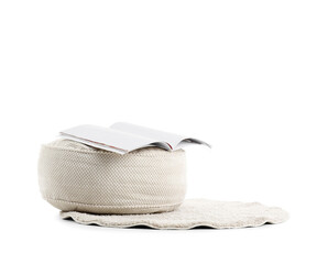 Poster - Comfortable soft pouf with magazine on rug on white background