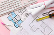 © Pixel-Shot - Architect's supplies with house plans and computer keyboard on pink background, closeup