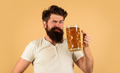 Beer pub or bar. Surprised bearded man drinking delicious lager beer at restaurant. Beer in Germany. Handsome male in casual wear with mug of fresh brewed beer. Holiday, drinks, alcohol and leisure.