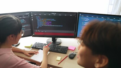 Slow motion back end software developer engineer for computer programming working together on debugging writing computing code, solving complex algorithms display on monitor in office. Burgeoning