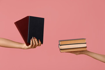 Wall Mural - Hands holding many books on pink background