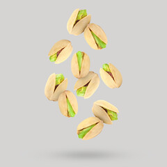 Canvas Print - Tasty pistachios falling on light grey background