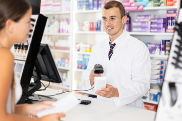 Wall Mural - Positive young man apothecary consulting customer holding medical prescription in drugstore