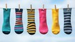 © artsGentor - A colorful assortment of knitted socks hanging on a line against a bright sky, showcasing various patterns and vibrant hues.