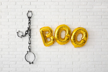 Wall Mural - Text BOO made of balloons and shackles hanging on light brick wall