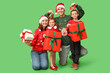 © Pixel-Shot - Happy family in Christmas clothes and gifts on green background