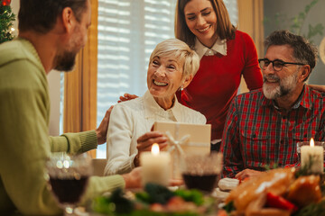 Wall Mural - Happy family celebrating christmas exchanging gifts at home