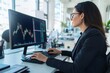 © Tondone - Businesswoman analyzing stock market data on a computer monitor in a modern office setting, focusing on financial growth and investment.