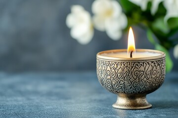 Poster - A candle is lit in a gold bowl on a blue surface