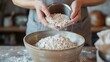 © Justlight - A person gracefully pouring a dash of buckwheat flour into a mixing bowl preparing to make homemade glutenfree buckwheat bread.