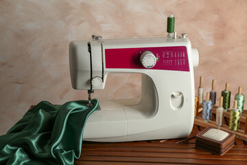 Poster - Sewing machine, green fabric and craft accessories on wooden table indoors