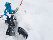 © Carolina Jaramillo - Traveling to the mountains in winter: woman clears snow from her vehicle, which is totally trapped, with a shovel; Mendoza, Argentina.