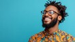 © IMAGINIAC - Portrait of a smiling man with dreadlocks wearing glasses and a patterned shirt