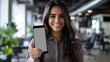 © Berkah - Smiling woman showing blank smartphone screen and thumb up.