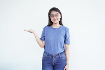 Beautiful Asian woman smiles while presenting a product on her open palm against a white background